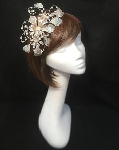 Delicate silver beige fascinator perfect for the guest who wants something fairly understated. This design is a beautiful selection of glass effect leaves and flowers clustered together and set onto a fine comfort base tiara band. As with all our designs, this piece can be made exact to the image or in any colour combination to match in with your outfit. If a specific colour is required customers can message over an image of their outfit and accessories, or if time allows customers are always we Adjustable Silver Headband Fascinator, Elegant Beige Headpieces With Handmade Flowers, Silver Bridal Headband For Party, Elegant Silver Fascinator For Wedding, Elegant Silver Headpiece With Structured Crown, Elegant Silver Wedding Fascinator, Silver Mini Hat For Wedding And Kentucky Derby, Cream Headband For Evening Events, Elegant Silver Bridal Headband