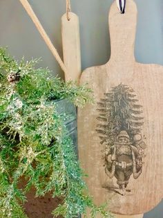 a wooden cutting board sitting next to a potted plant