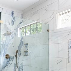 a bathroom with marble walls and flooring, including a walk - in shower area