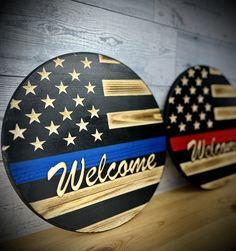 two wooden signs with the words welcome and an american flag on them are sitting on a shelf