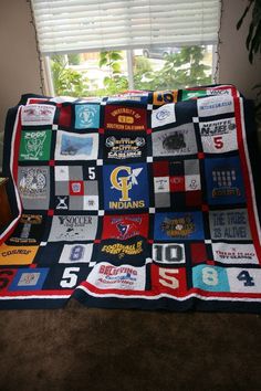 a quilt made to look like it has many different patches on it and is sitting in front of a window