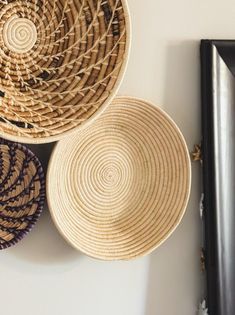 three woven baskets hanging on the wall