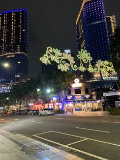 an empty city street at night with tall buildings in the background