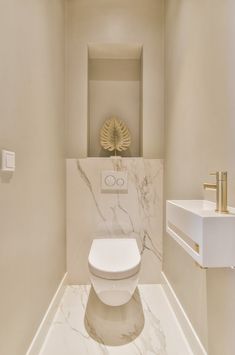 a white toilet sitting inside of a bathroom next to a wall mounted faucet