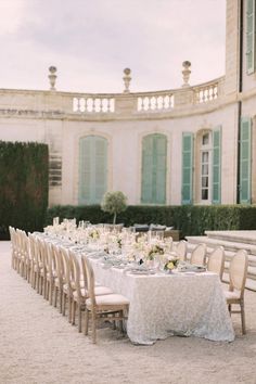 a long table is set up outside with white linens