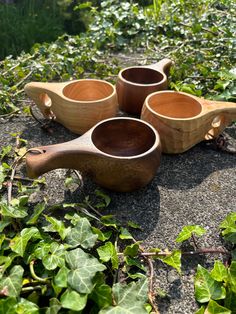 four wooden bowls sitting on top of a rock