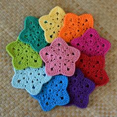 crocheted coasters are arranged on a woven mat