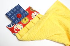 three pairs of yellow socks sitting next to each other on a white surface with buttons