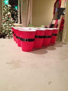 three red buckets sitting on top of a white table next to a christmas tree