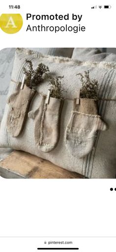 an old pair of oven mitts is hung on a pillow with plants in them