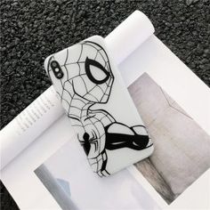 a spider man phone case sitting on top of a white paper next to a roll of toilet paper