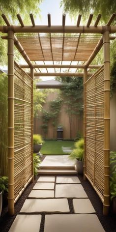 an outdoor walkway with stepping stones and bamboo screens on the sides, leading to a small garden