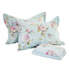 three pillows and two pillow cases with floral print on the front, one is light blue