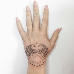 a woman's hand with tattoos on it and the words tattoocomption written in black ink