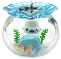 a clear glass fish bowl with a blue bear in it's belly and seaweed