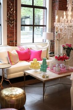 a living room filled with lots of furniture and flowers on top of a coffee table