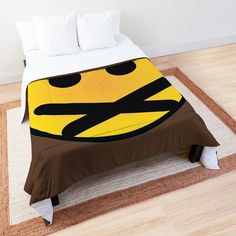 a bed with a yellow smiley face on it's head and brown pillowcase