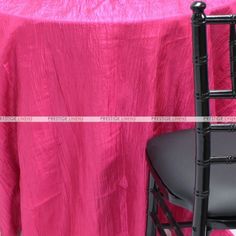 a pink table cloth with black chairs and a chair on the floor next to it