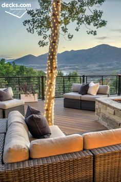 an outdoor patio with wicker furniture and lights on the trees is featured in this post