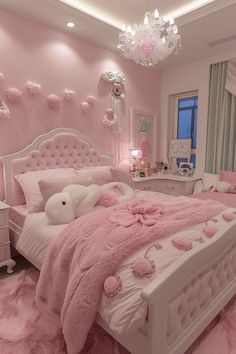 a bedroom decorated in pink and white with teddy bears on the bed, chandelier