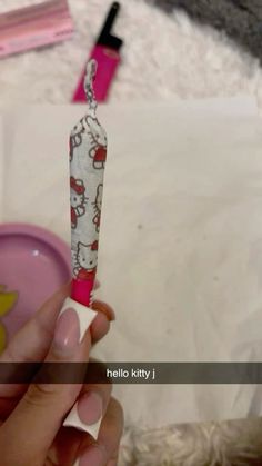 a person is holding a hello kitty toothbrush in their left hand and the other one has a pink cup with hello kitty on it