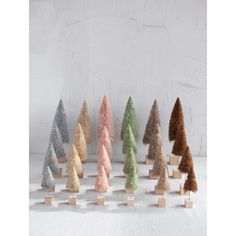 a group of small wooden trees sitting on top of a white table next to each other