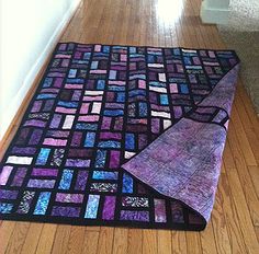 a purple and black area rug on the floor