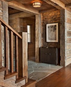 the interior of a rustic log cabin with wood floors and stonework on the walls