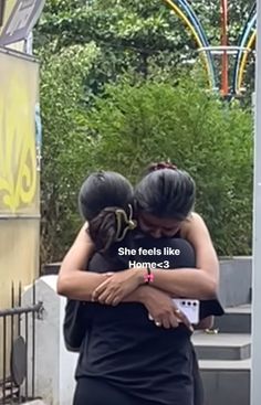 two women hugging each other outside