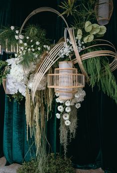 a birdcage filled with white flowers and greenery