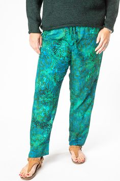 A combination of cool comfort and colorful hippie style are all yours when you slip into these breezy batik straight legged lounge pants. Featuring flowing rayon fabric and an elasticized waist with a drawstring for a cozy and comfortable fit. Each pair of drawstring comfy pants was hand dyed and ethically made by our makers in Bali. The traditional Indonesian batik dye process is an ancient artform and each pair of one of a kind pants helps support this ancient artistic tradition. The perfect p Green Rayon Beach Bottoms, Tropical Green Bottoms With Elastic Waistband, Green Rayon Bottoms For Vacation, Casual Multicolor Rayon Pants, Green Rayon Casual Bottoms, Green Casual Rayon Bottoms, Casual Green Rayon Bottoms, Casual Green Rayon Pants, Casual Batik Print Bottoms For Summer