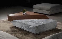 a marble coffee table sitting on top of a rug next to a gray couch and chair