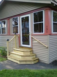 a small house with steps leading up to the front door and windows on each side