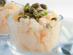 two small glass bowls filled with food on top of a table