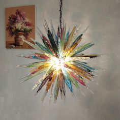 a chandelier hanging from the ceiling in a room with pictures on the wall