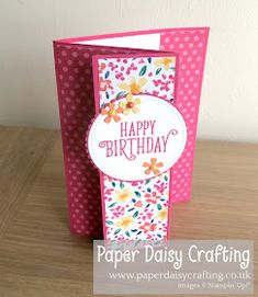 a birthday card with flowers and polka dots on the front, sitting on a table