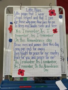 a piece of paper taped to a bulletin board with writing on it and red poppies