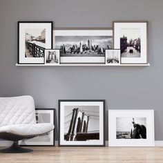 a white chair sitting in front of pictures on the wall