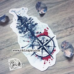 a sticker with a compass and trees on it sitting next to some crystal stones