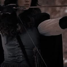 a woman holding a bow and arrow in her hands