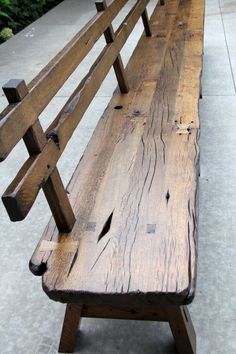 a wooden bench sitting on top of a sidewalk