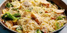 a pan filled with pasta and vegetables on top of a table