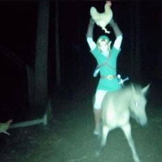 a woman is riding on top of a donkey in the dark with her arms up