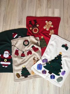 four christmas sweaters are laying on the floor