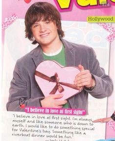 an advertisement for valentine's day with a young man holding a heart shaped box