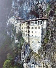 an old castle built into the side of a mountain with lots of windows on it