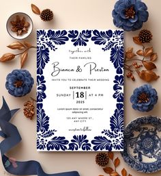 a blue and white wedding card surrounded by flowers