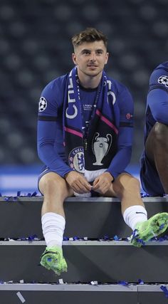 two soccer players sitting on the bench during a game