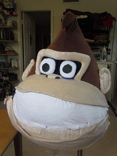 a stuffed monkey with big eyes and a hat on top of it's head