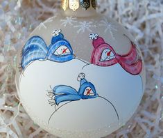 a glass ornament with two blue birds on it's side and one red bird in the middle